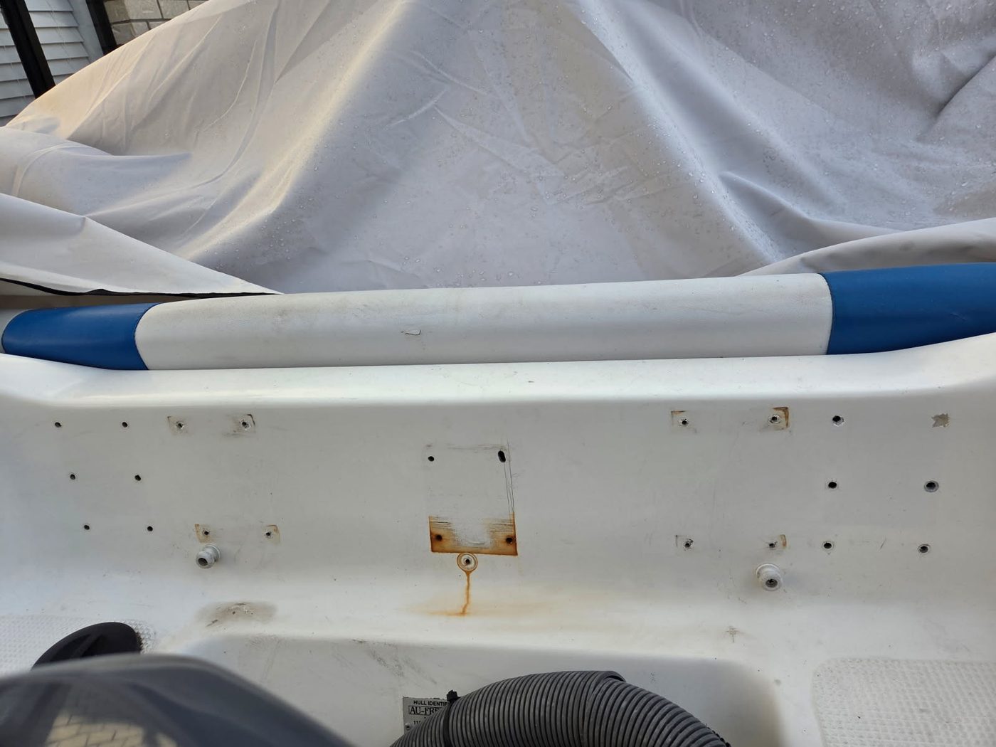 Boat transom with old fastener holes and rust staining before fibreglass repair, Brisbane