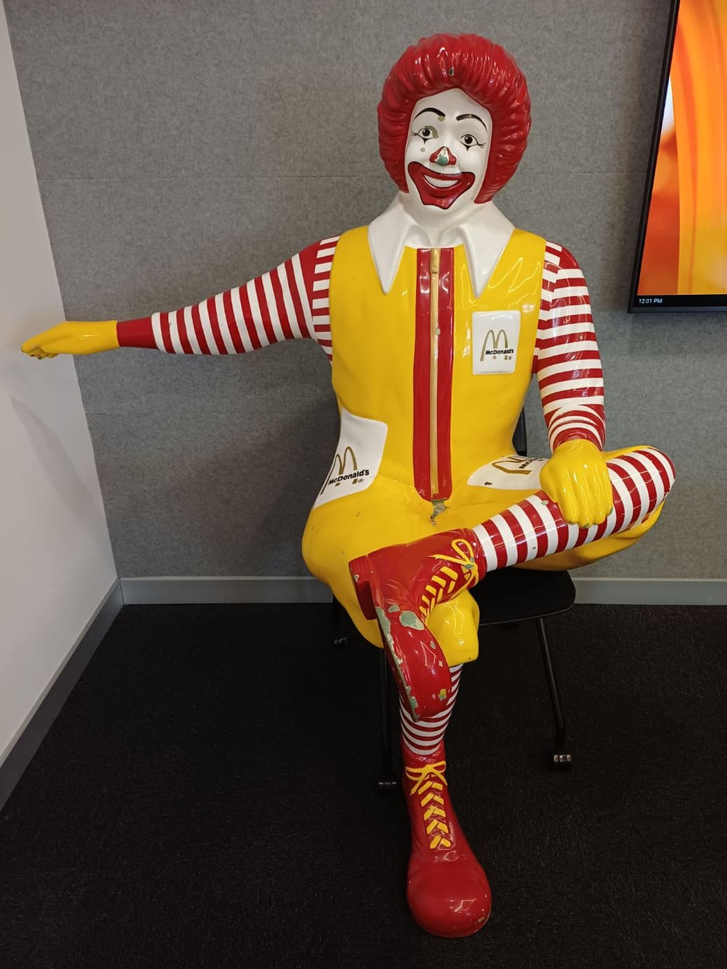 Large seated fibreglass character statue with chipped boots and legs before restoration, Brisbane