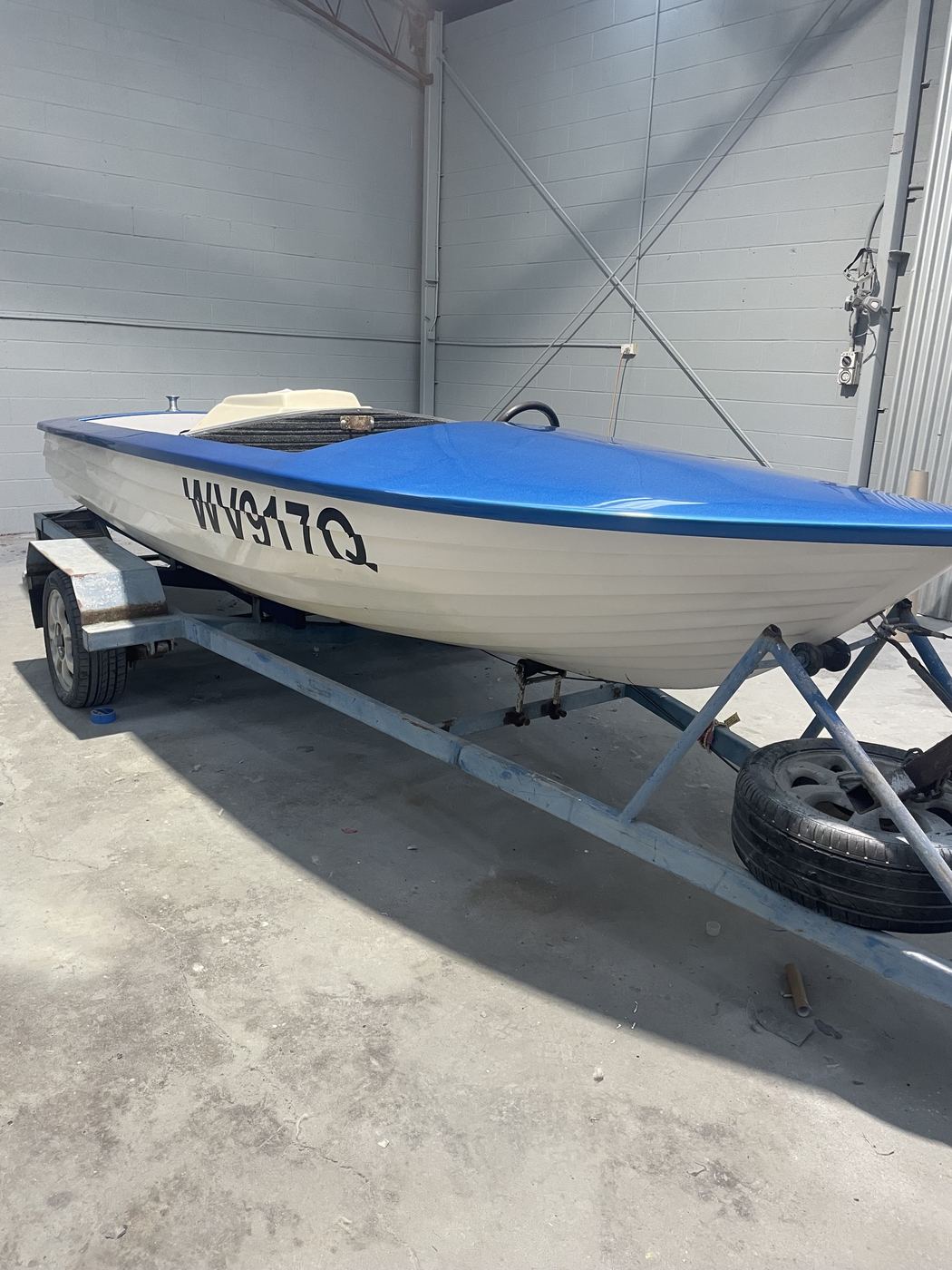 Clinker-hull ski boat on its trailer with the top deck resprayed in blue metal-flake, Brisbane