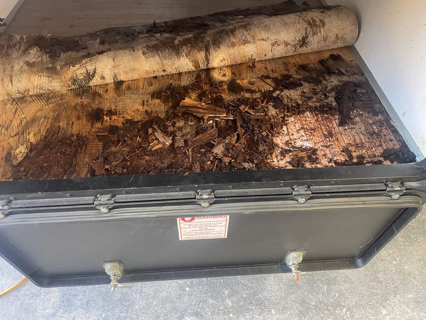 Rotted timber trailer floor exposed under lifted vinyl before fibreglass floor rebuild, Brisbane